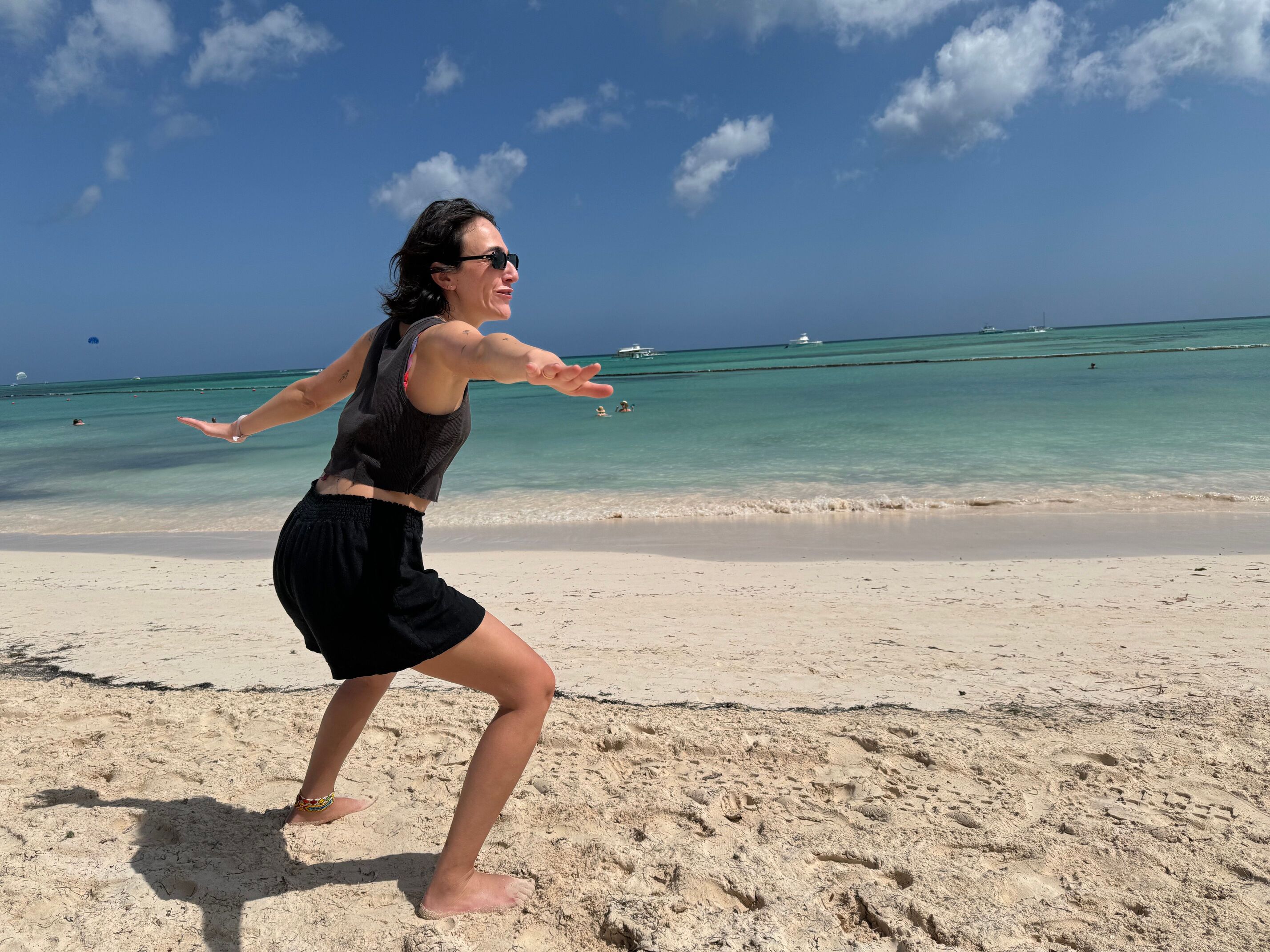 a woman is doing a yoga pose on the beach .