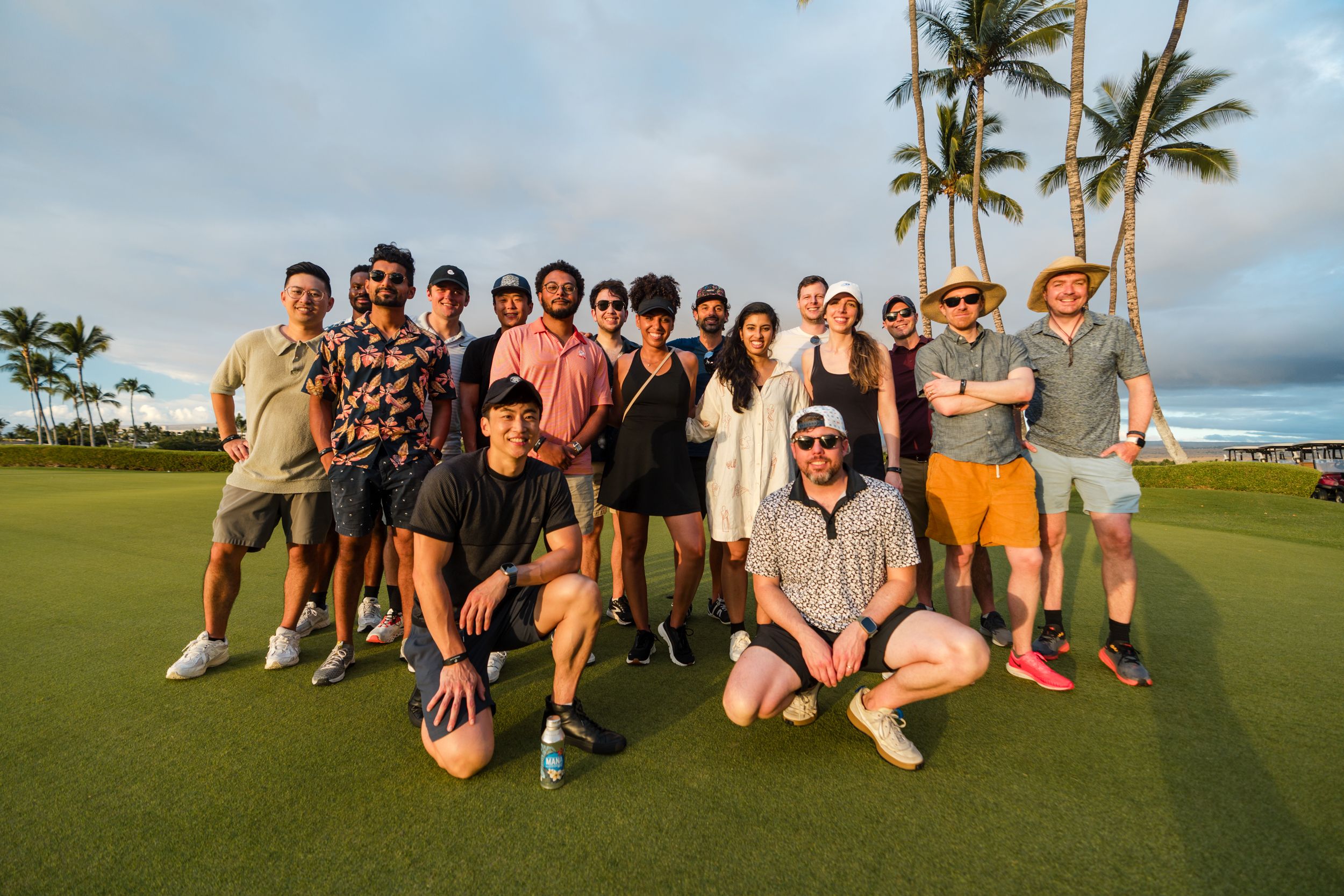 a group of people are posing for a picture on a golf course .
