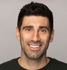 a man in a black shirt is smiling for the camera .